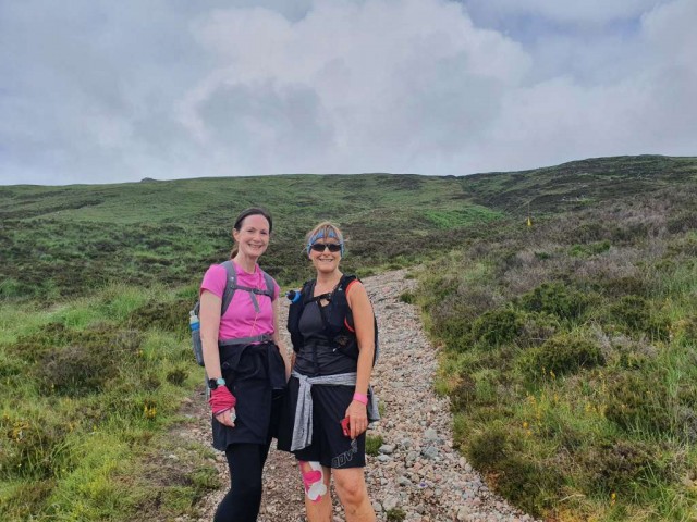 2 ladies standing in the mountains.