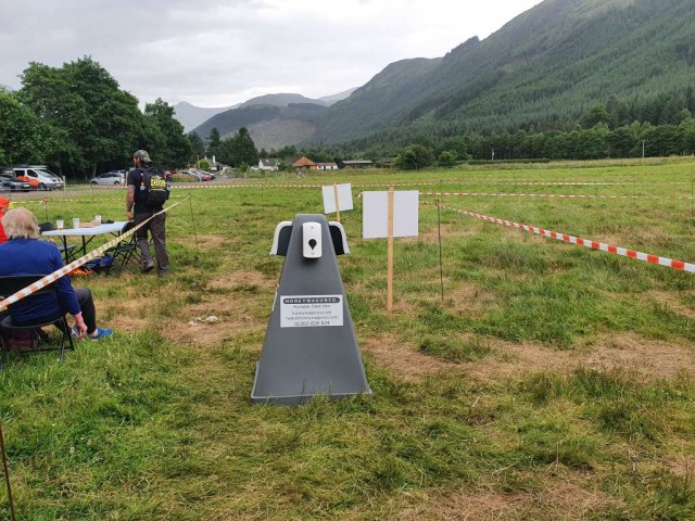 Hand Sanitizer Dispenser in a field with mountains in the background.