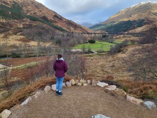Girl looking out at the mountains and a railway bridge