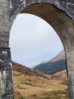 Bridge arch with mountains in the distance